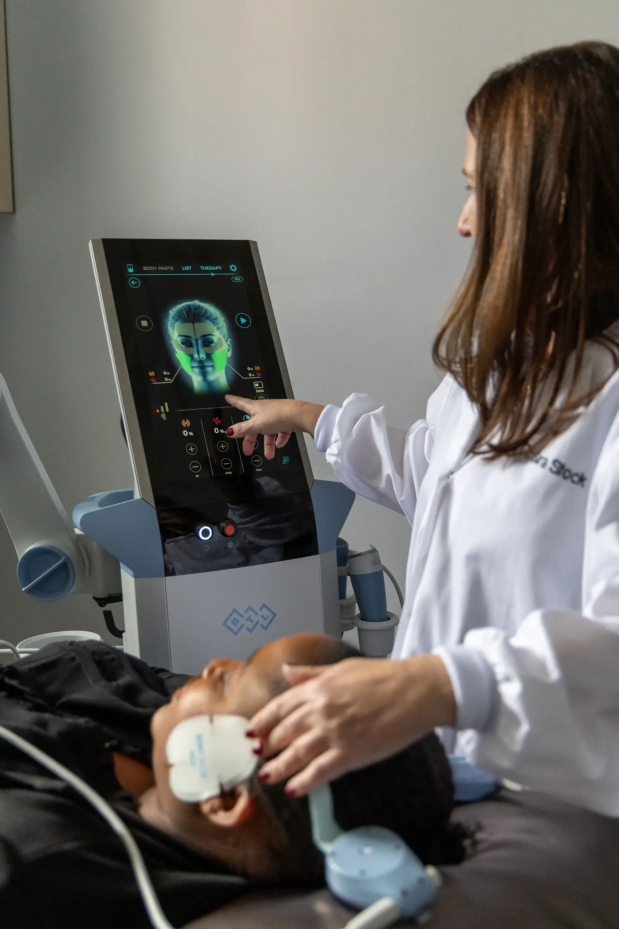 Patient describing tight jaw muscles and temple tension during a TMJ exam at Smile Brookline Brookline MA
